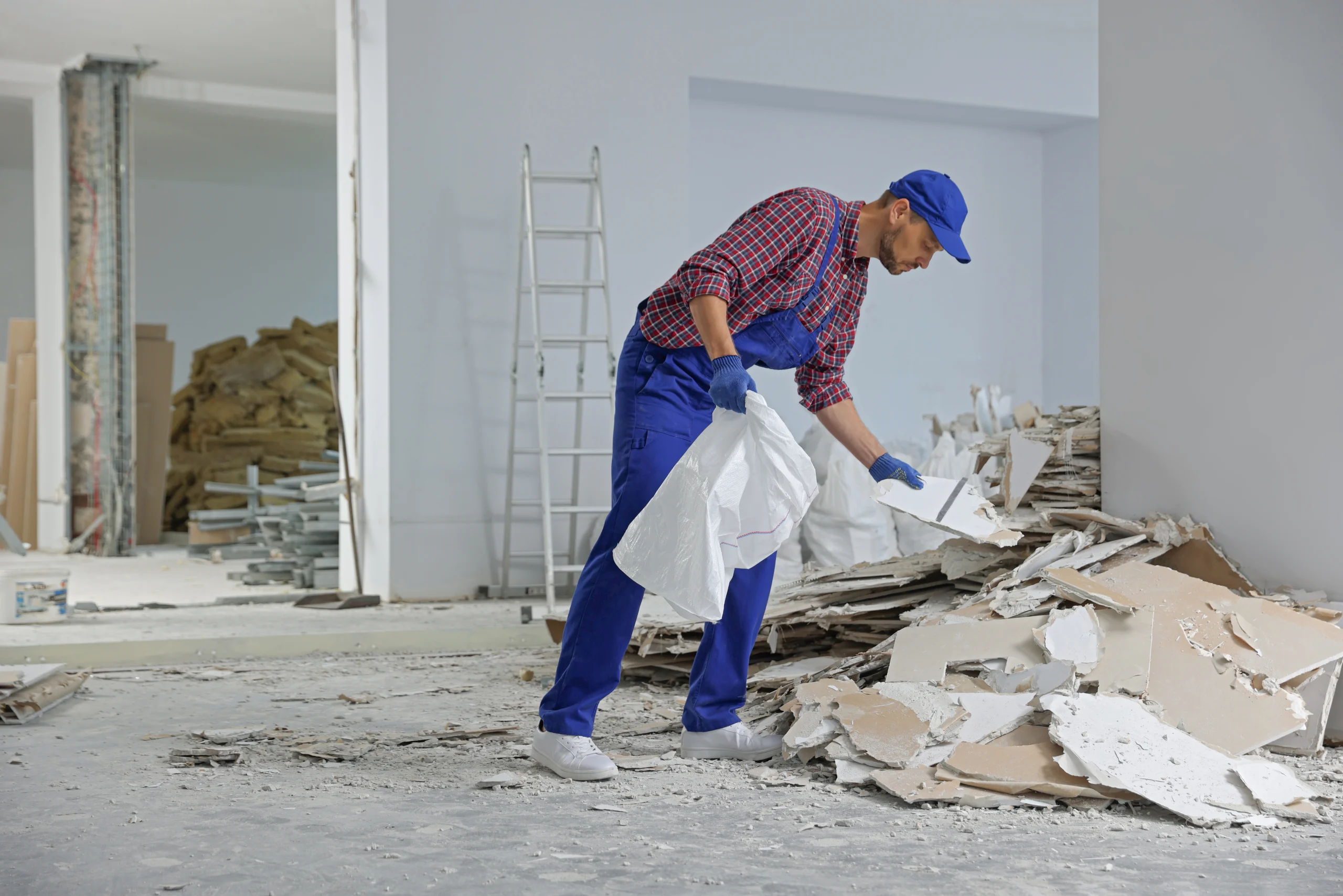 Arbeiter räumt bei der Baugrobreinigung Bauschutt aus einem Rohbau